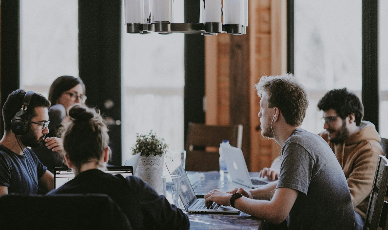 Equipo de trabajo reunido en una mesa con sus laptops